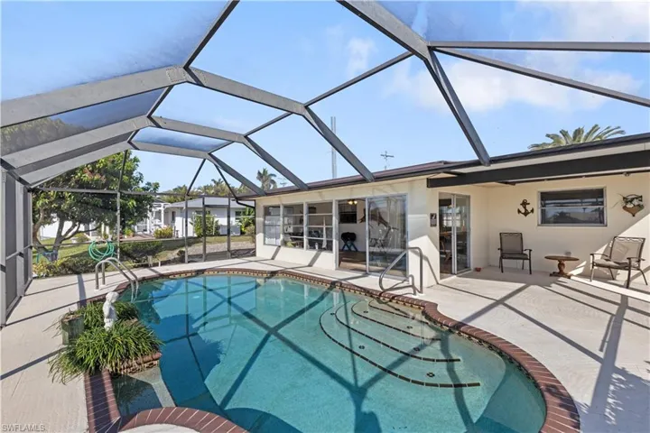 View of pool featuring a patio and glass enclosure