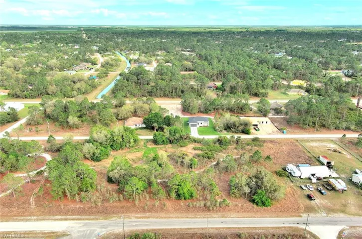 Aerial view of property's location with a heavily wooded area