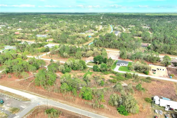 Aerial view of property and surrounding area featuring a forest