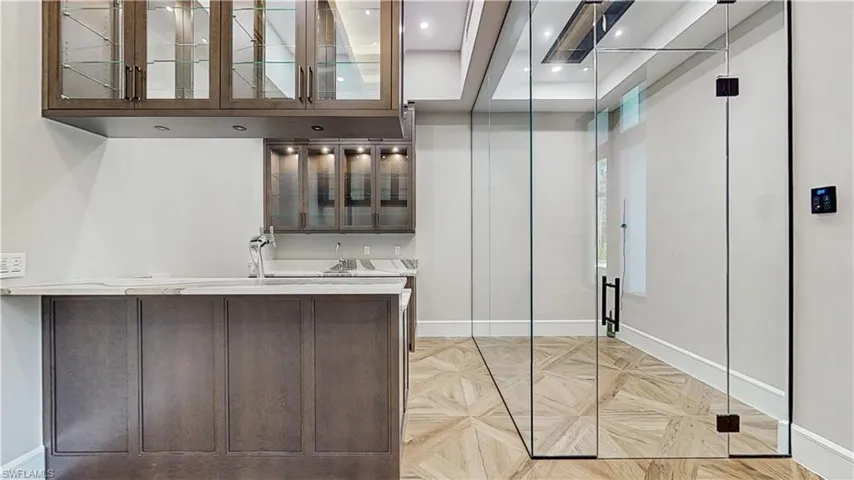 Bar with hanging light fixtures and dark brown cabinetry