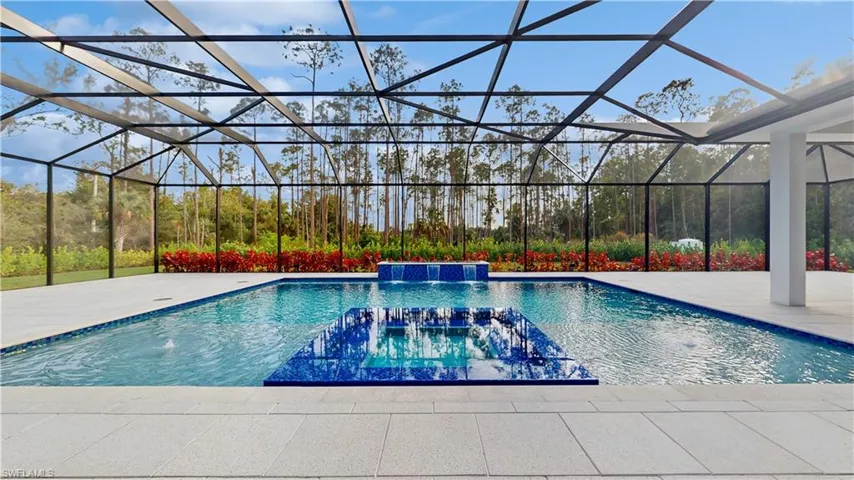 View of pool featuring pool water feature, a lanai, a hot tub, and a patio area