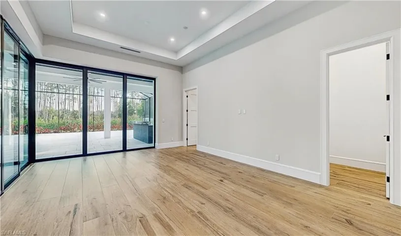 Spare room featuring light wood-type flooring and a tray ceiling