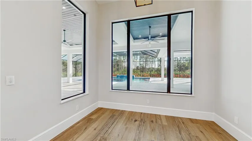 Empty room with light wood-type flooring, ceiling fan, and a wealth of natural light