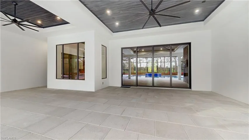 Empty room featuring a raised ceiling, ceiling fan, and wood ceiling