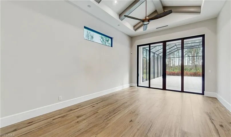 Unfurnished room featuring ceiling fan, light wood-type flooring, high vaulted ceiling, and beamed ceiling