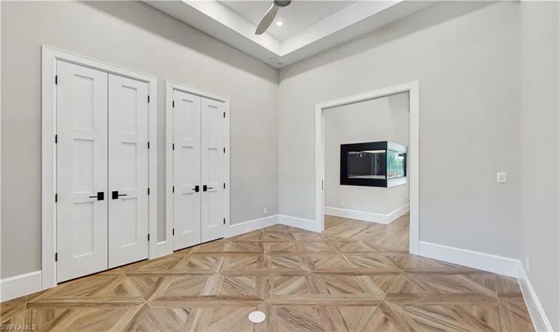 Foyer with ceiling fan and light parquet flooring