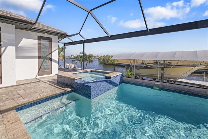 View of swimming pool featuring boat lift, a boat dock, a sunroom, and a lanai