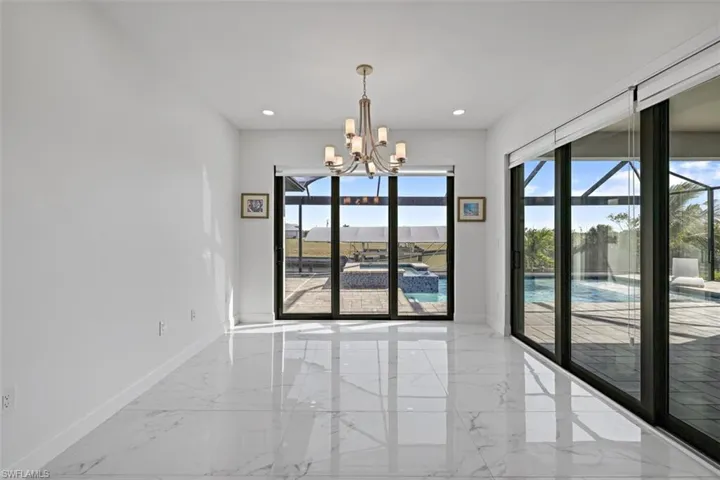 Unfurnished room featuring light marble finish floors, a chandelier, and recessed lighting