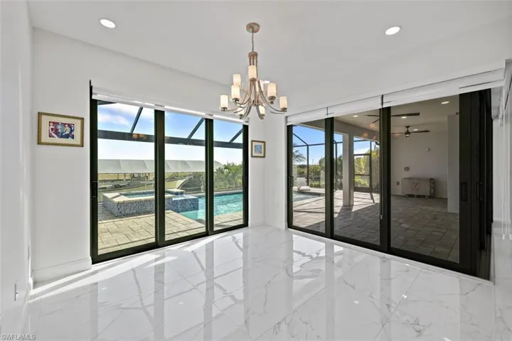 Empty room featuring marble tiled flooring, a sunroom, recessed lighting, a ceiling fan, and a chandelier