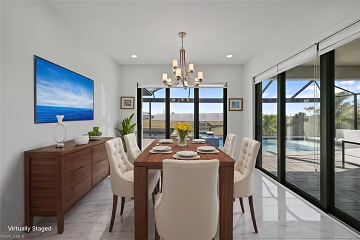 Dining space featuring light marble finish floors, a chandelier, and recessed lighting