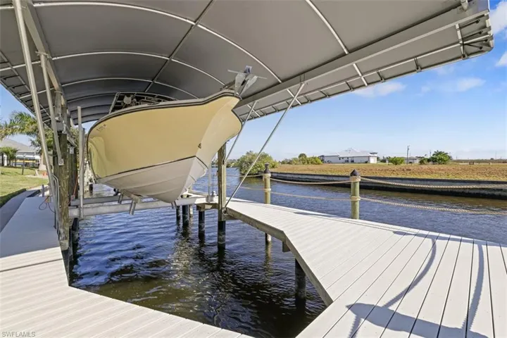Dock area featuring boat lift and a water view