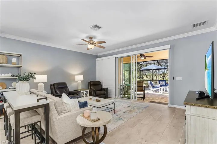 Living area with ornamental molding and ceiling fan