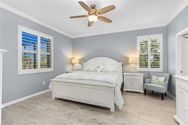Bedroom with ceiling fan and ornamental molding