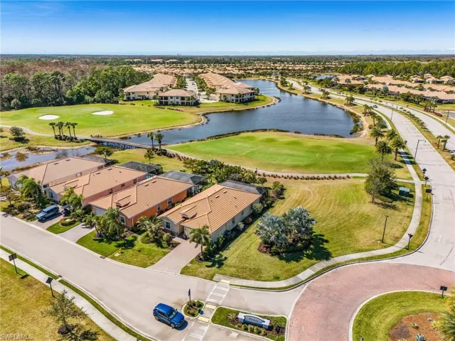 Aerial view of residential area featuring a golf course and a large body of water