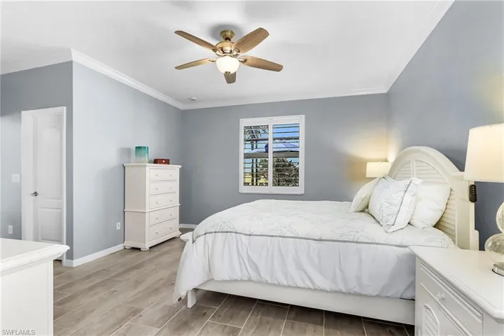 Bedroom featuring ornamental molding, wood finish floors, and ceiling fan