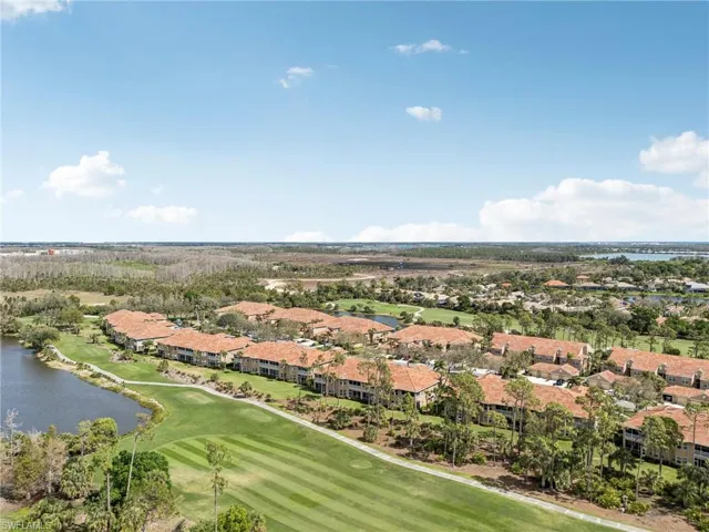 Aerial view featuring golf course view, a water view, and a residential view