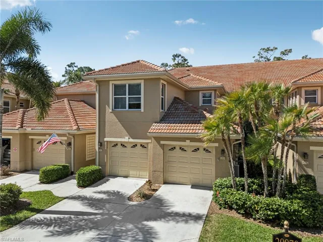 View of front of home featuring driveway, a tiled roof, and stucco siding