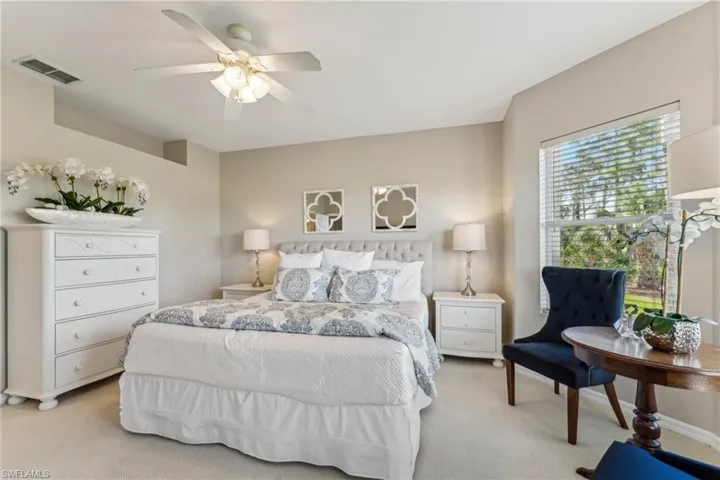 Bedroom featuring a ceiling fan, light colored carpet, visible vents, and baseboards