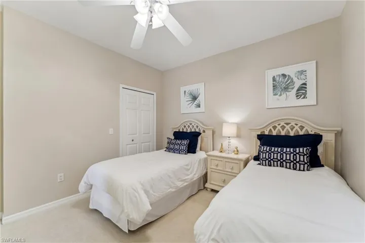 Bedroom featuring ceiling fan, baseboards, a closet, and light colored carpet