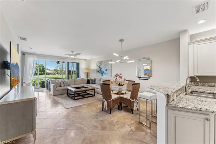 Dining room with ceiling fan with notable chandelier and visible vents