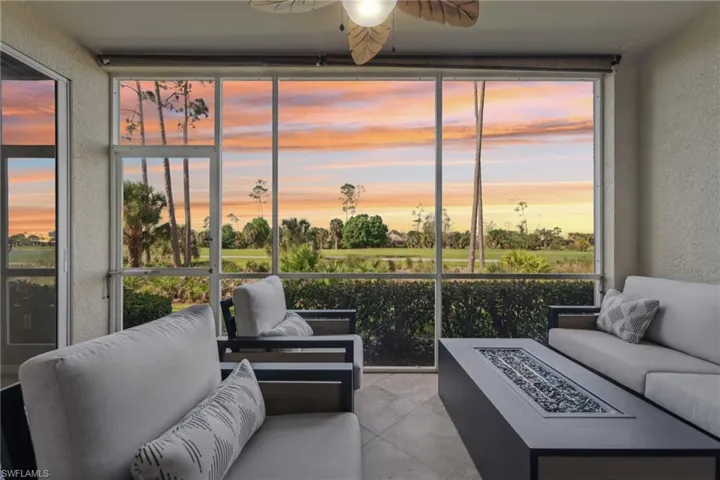 Living area featuring light tile patterned floors, a textured wall, a sunroom, a ceiling fan, and floor to ceiling windows
