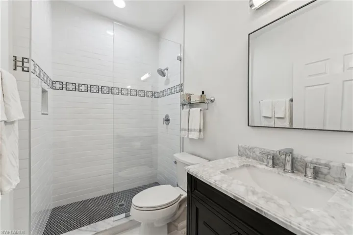 Full bath with a stall shower, vanity, and toilet