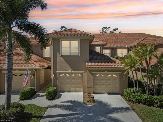 View of property with an attached garage, a tile roof, concrete driveway, and stucco siding