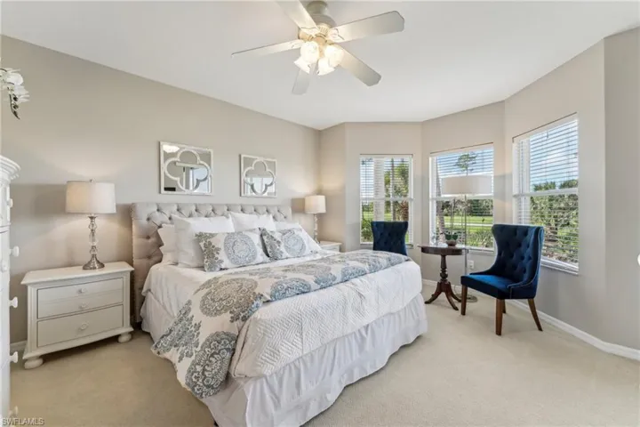 Bedroom featuring baseboards, multiple windows, and light colored carpet