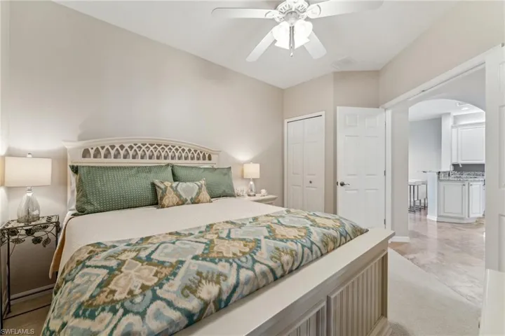 Bedroom featuring arched walkways, ceiling fan, a sink, visible vents, and a closet