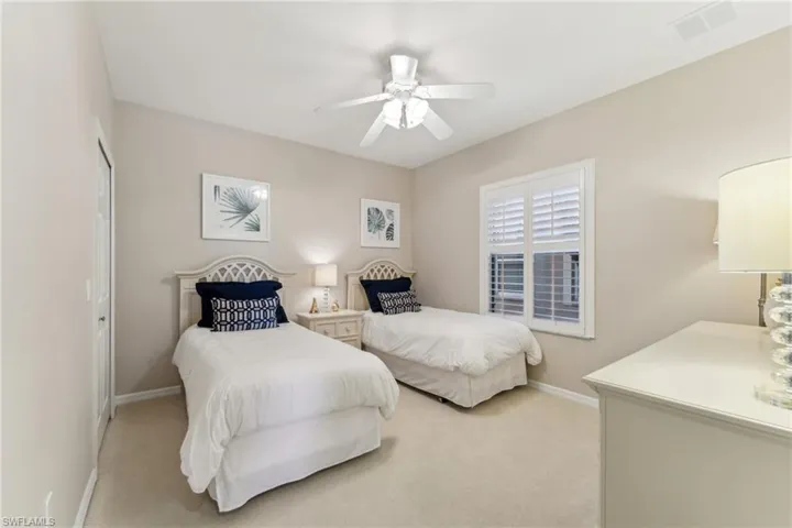 Bedroom featuring a ceiling fan, visible vents, light carpet, and baseboards