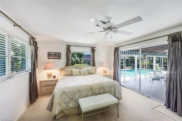 The Primary Suite occupies one end of the home and offers direct access to the screened lanai and pool