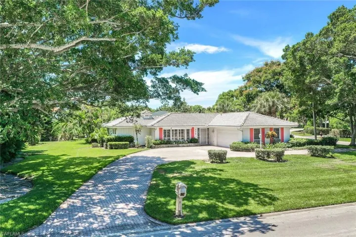 The property is framed by two majestic Ficus trees
