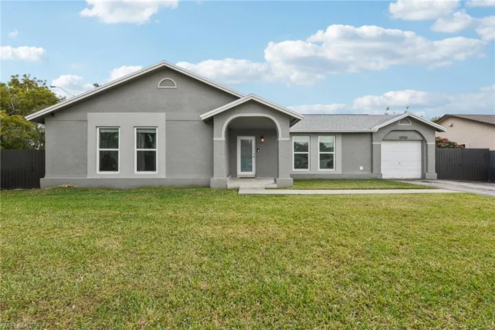 Ranch-style house with a front yard and a garage