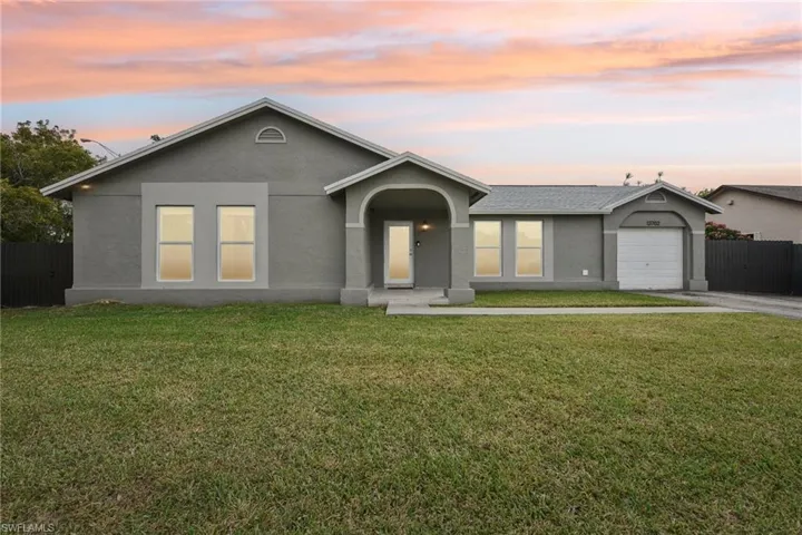 Ranch-style house with a garage and a yard