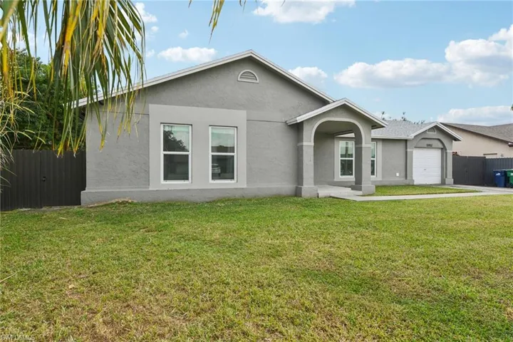 Single story home with a garage and a front yard