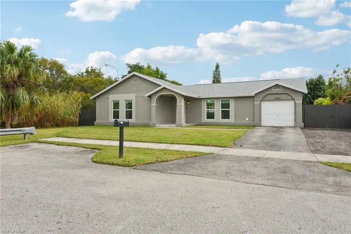 Ranch-style house featuring a front lawn and a garage