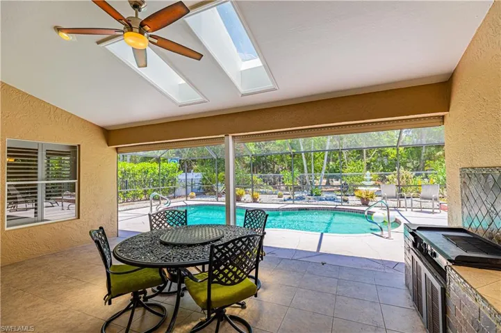 View of swimming pool featuring ceiling fan and a skylight