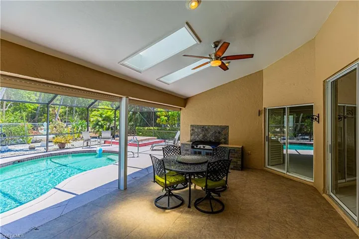 View of pool with ceiling fan and a skylight