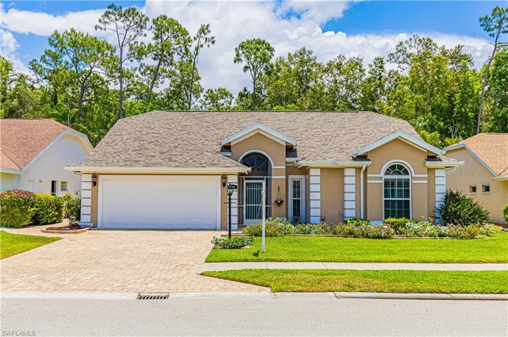 Ranch-style house featuring a front yard and a garage