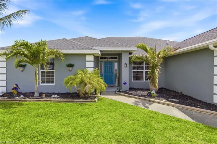Step through a welcoming entry framed by lush greenery and thoughtful landscaping.