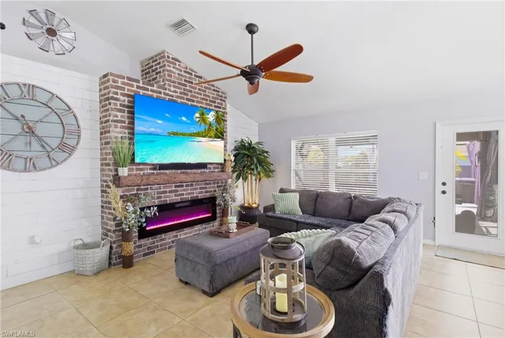 Expansive living area featuring a striking brick accent wall and cozy electric fireplace.