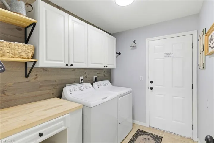 Designed for practicality and ease, this laundry area combines counter space with ample cabinetry for all your needs.