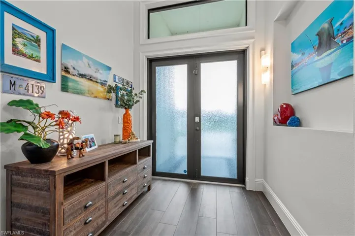 Entryway with dark wood finished floors and baseboards
