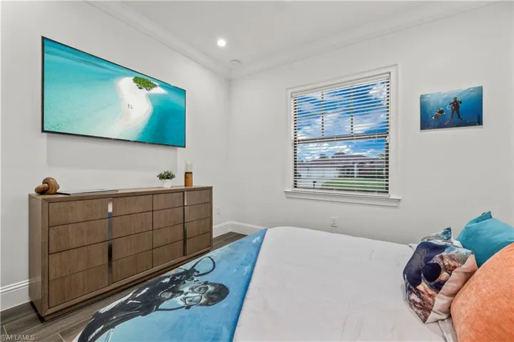 Bedroom featuring recessed lighting, baseboards, wood finished floors, and ornamental molding