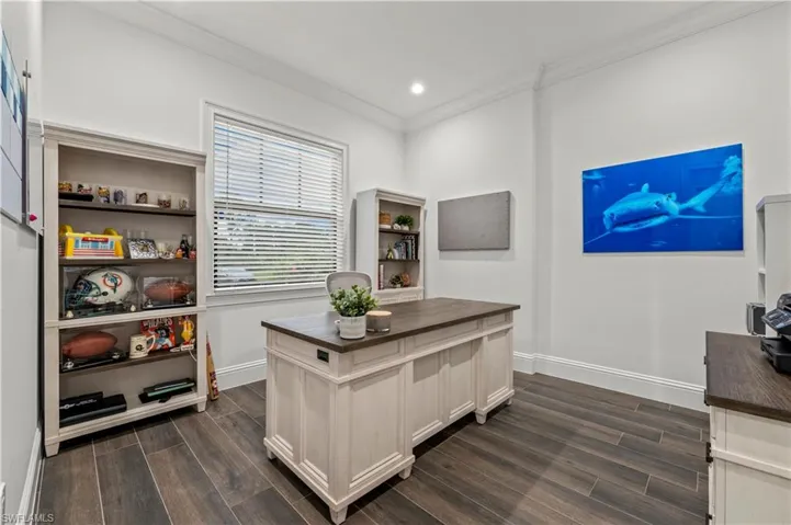 Office space with recessed lighting, crown molding, baseboards, and dark wood-style flooring