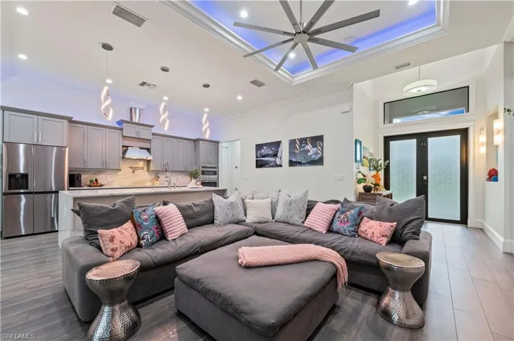 Living area featuring crown molding, a ceiling fan, and visible vents