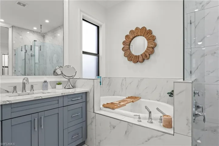 Full bath featuring vanity, visible vents, a marble finish shower, recessed lighting, and a garden tub