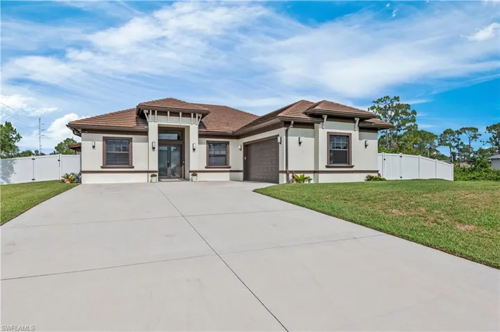 Prairie-style house featuring concrete driveway, a front yard, french doors, a garage, and a gate
