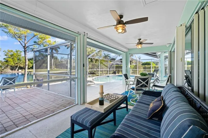 Sunroom featuring ceiling fan and a water view
