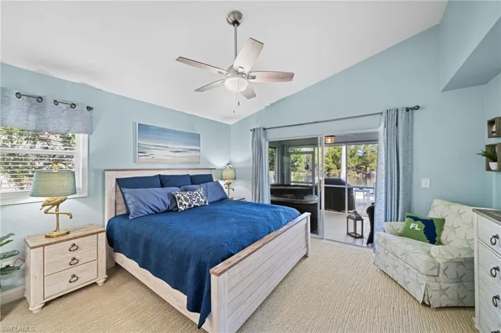 Bedroom featuring multiple windows, vaulted ceiling, and ceiling fan